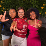 Adélia Pinheiro ao centro, ao lado de duas pessoas, durante atividade de campanha
