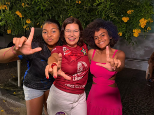Adélia Pinheiro ao centro, ao lado de duas pessoas, durante atividade de campanha
