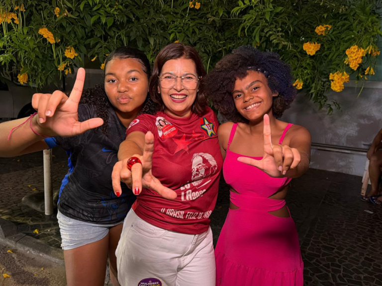 Adélia Pinheiro ao centro, ao lado de duas pessoas, durante atividade de campanha