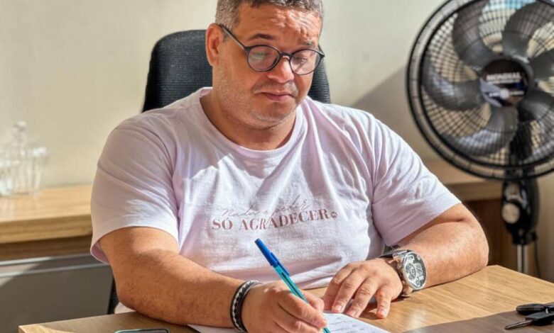Professor Emenson Silva escrevendo à mesa