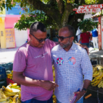 Bebeto conversa com comerciante ao lado de uma banca de frutas no bairro Nelson Costa, em Ilhéus