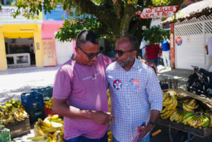 Bebeto conversa com comerciante ao lado de uma banca de frutas no bairro Nelson Costa, em Ilhéus