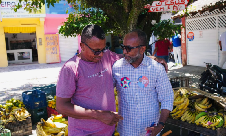 Bebeto conversa com comerciante ao lado de uma banca de frutas no bairro Nelson Costa, em Ilhéus